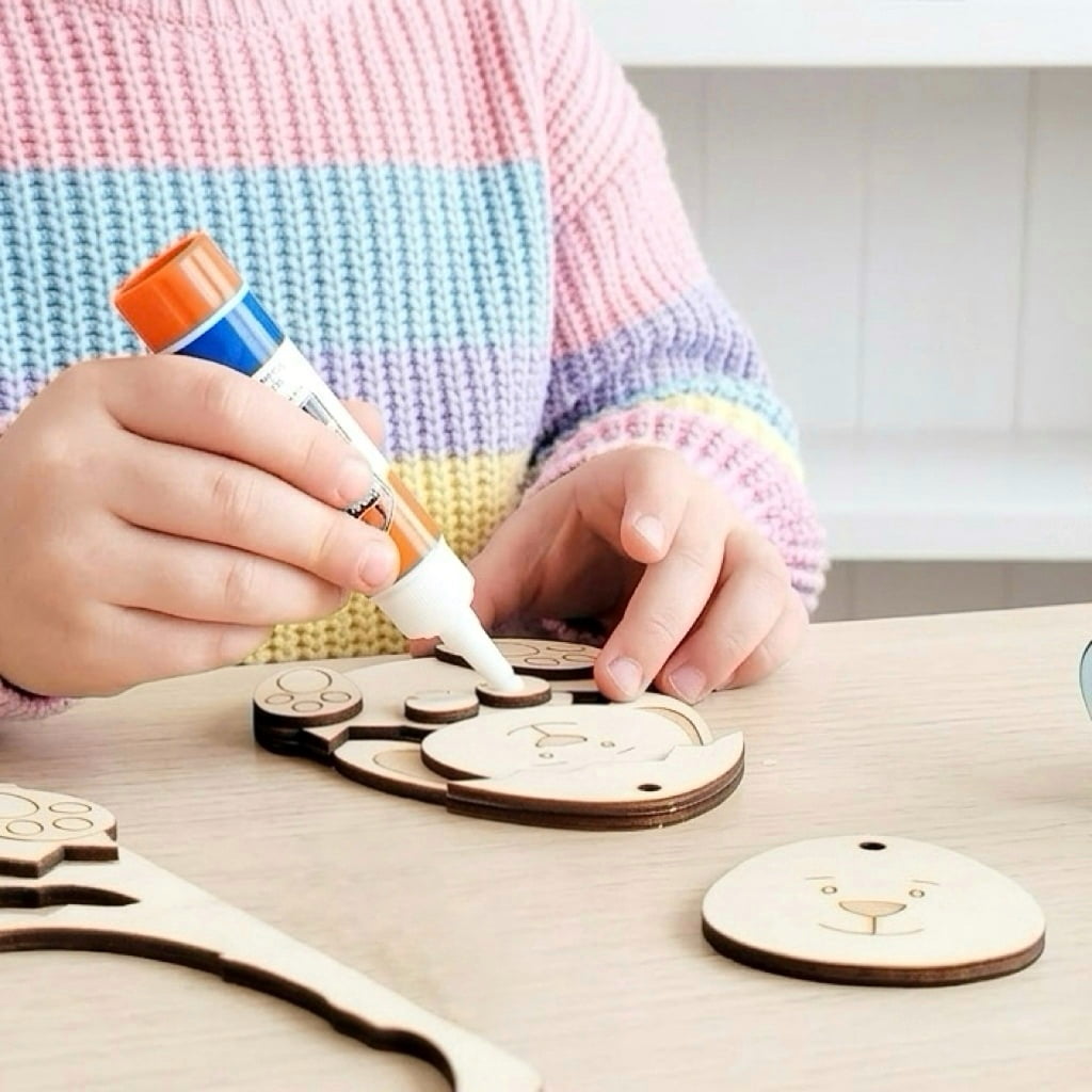 Child assembling wooden Easter bunny craft using glue as part of personalized DIY Easter activity kit